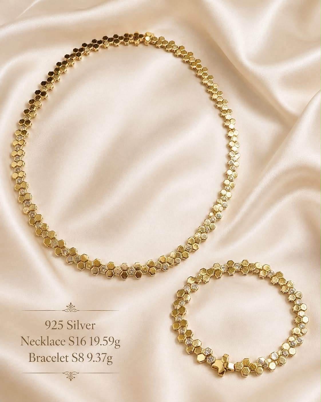 Gold-tone honeycomb hexagon necklace and matching bracelet on cream silk